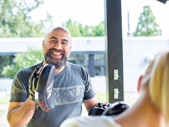 Ein CJD Mitarbeiter mit Box-Handschuhen bei einem Coaching.