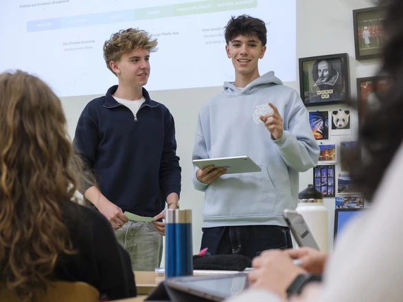 2 junge Männer die etwas vortragen mit I-Pad in der Hand